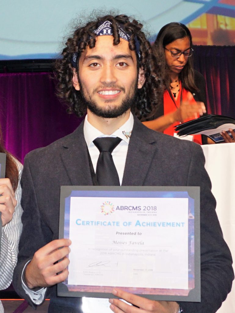 Moisés Favela posing with certificate of acheivment